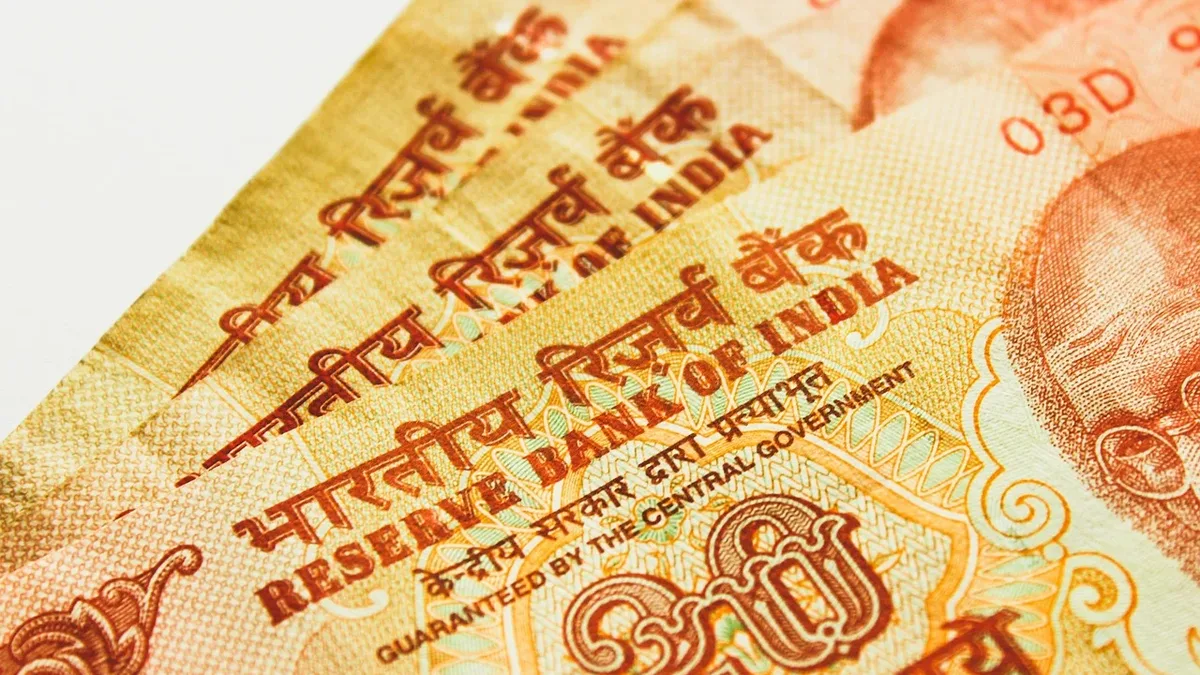 A close-up of an Indian 20 rupee note, featuring the Reserve Bank of India logo and the denomination "20" in red text.